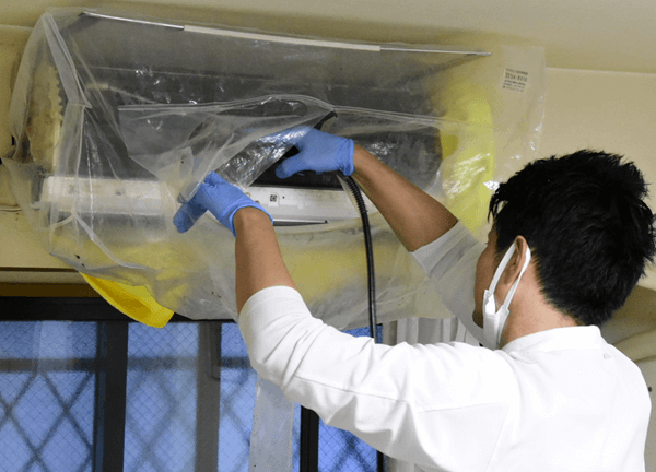 くらしのマーケット お掃除機能つきエアコンを高圧洗浄機で洗っている様子